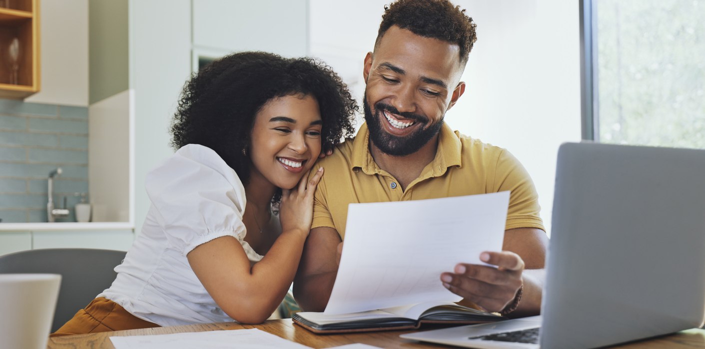 Couple celebrating financial freedom, using laptop, banking reports or statements to calculate budget, savings and finance. Happy debt free girlfriend and boyfriend with mortgage home loan approval
